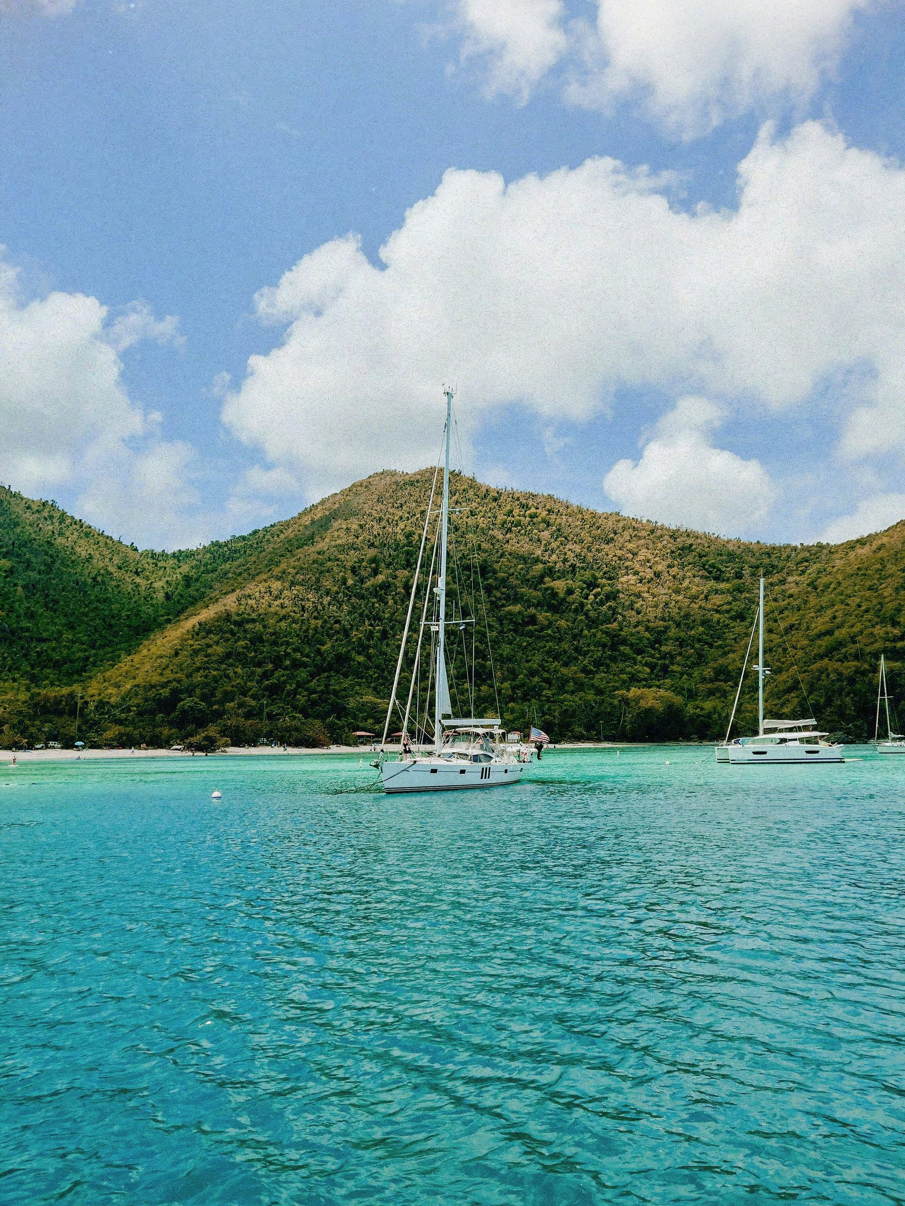Yachts at anchor below green hills, Mustique, Caribbean
