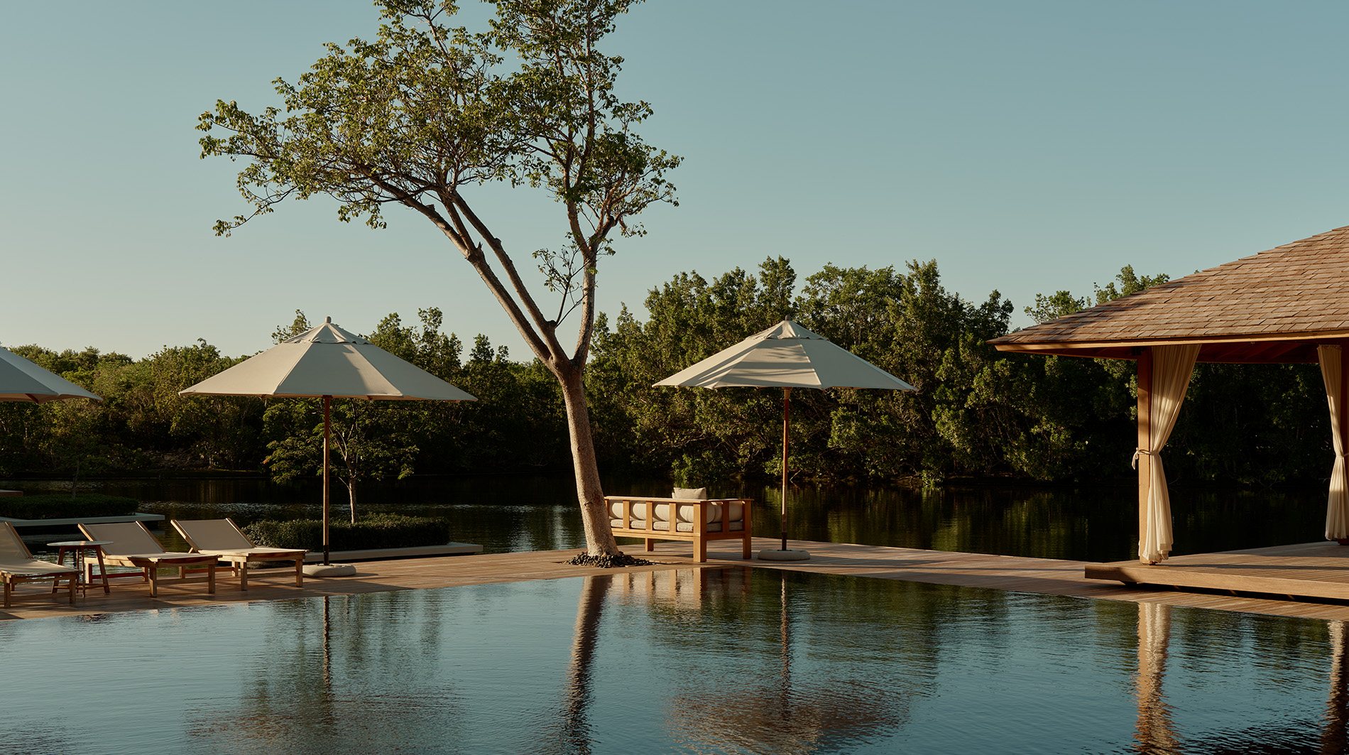 A timber pavilion at Amanyara framed by reflecting ponds and tropical planting