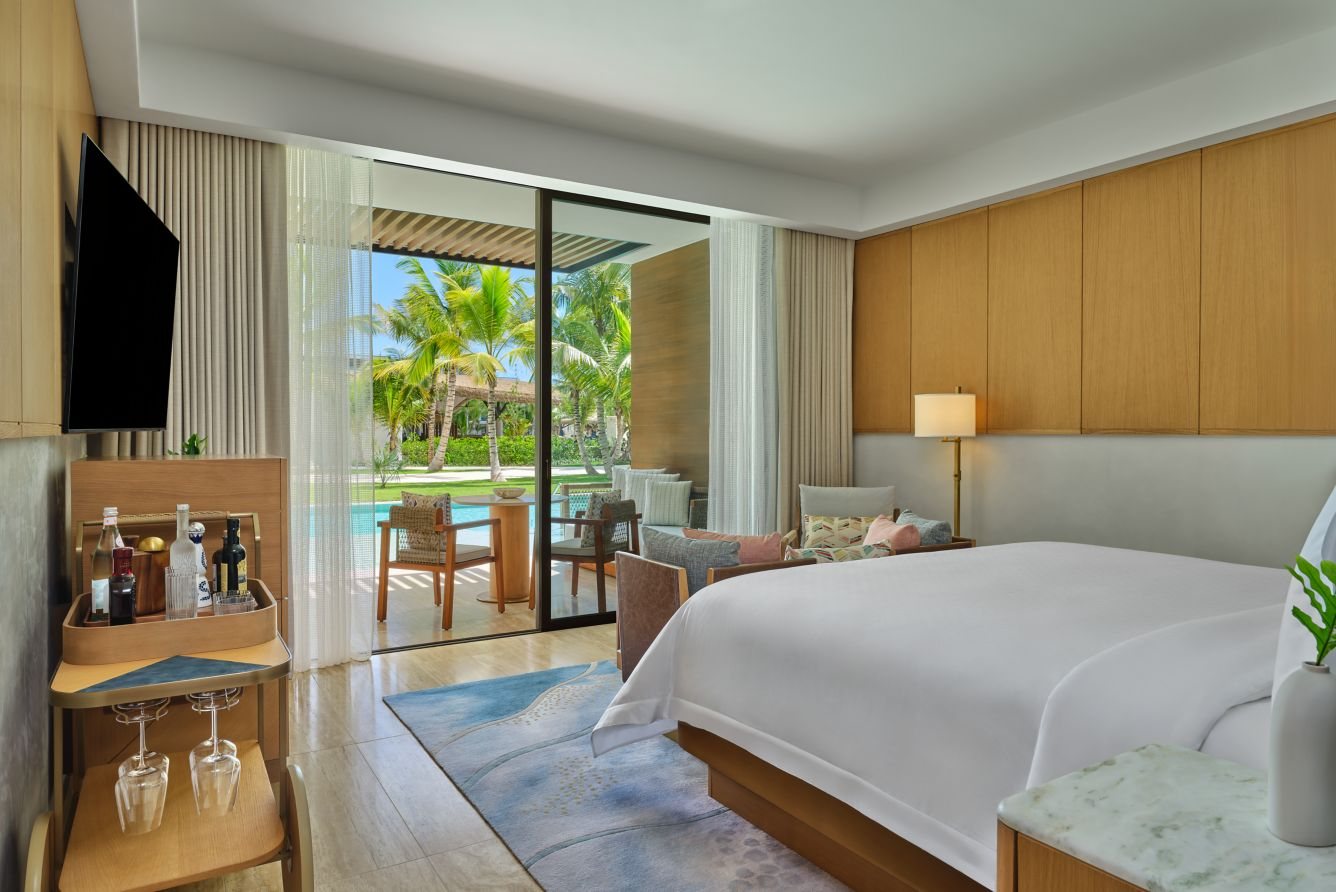 A pool-facing king room at St Regis Cap Cana opening onto a terrace and the resort gardens