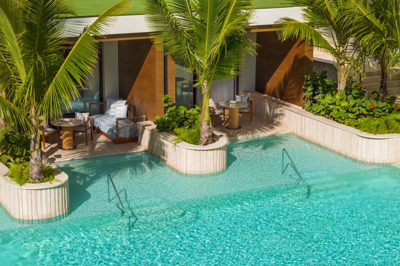 A swim-up suite at St Regis Cap Cana with a terrace stepping straight into a turquoise lagoon pool