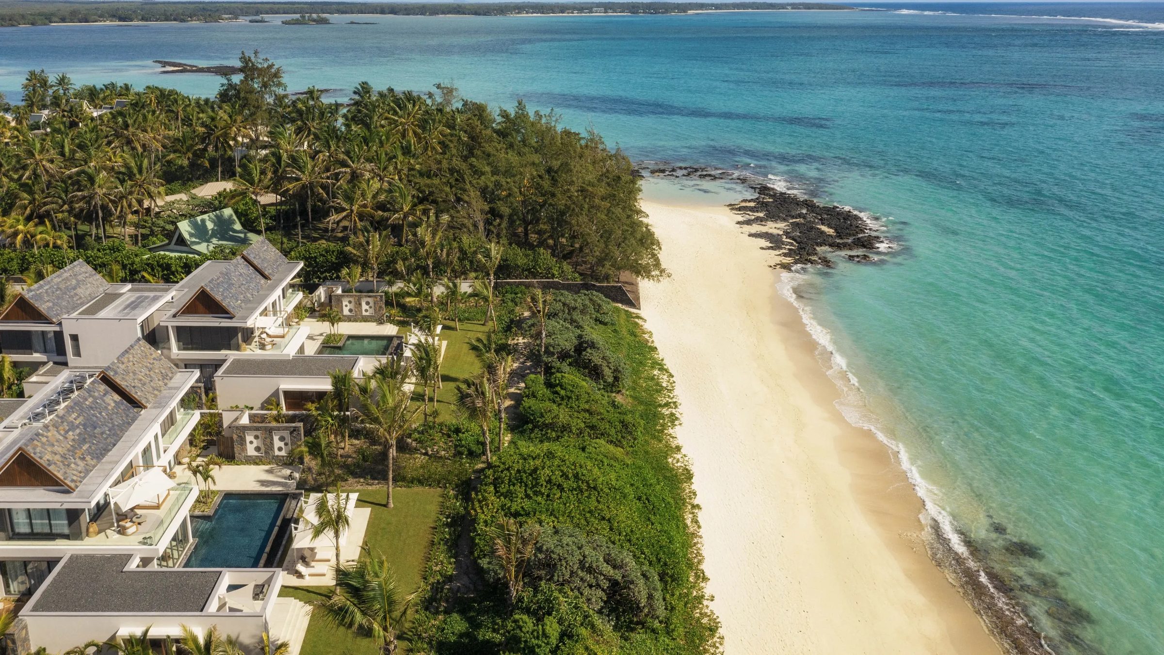 Aerial of beachfront villas and pools on the peninsula, One&Only Le Saint Geran, Mauritius