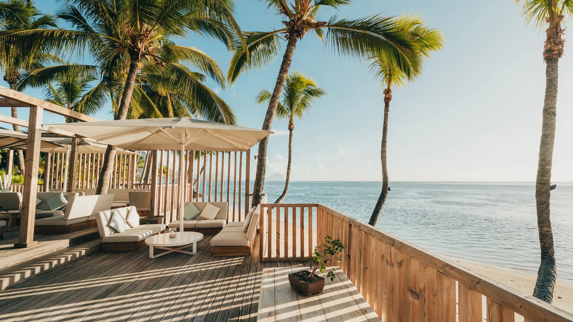 A shaded beach deck above the water at golden hour, Sugar Beach Mauritius