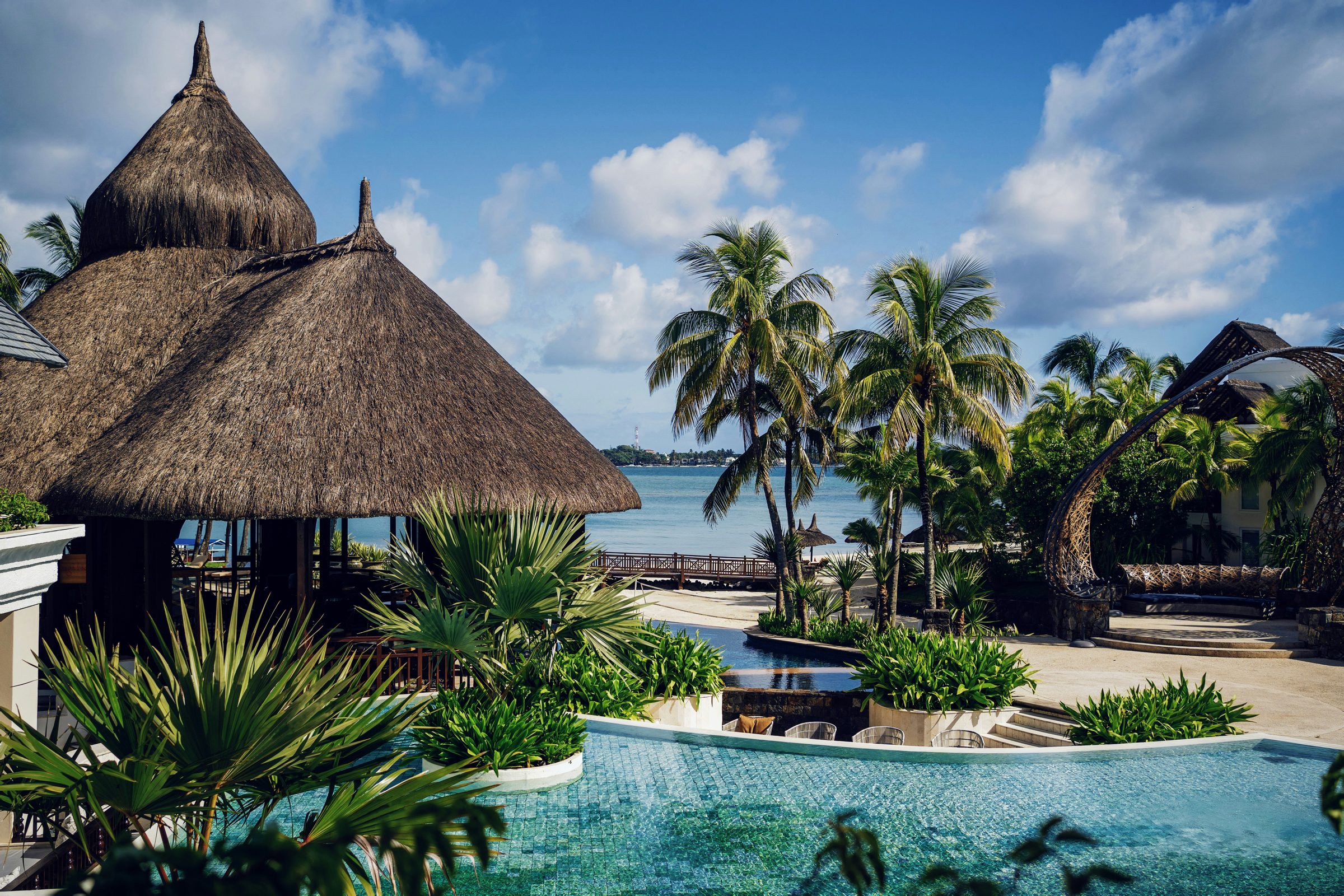 Thatched resort pavilions and a pool beside the lagoon, the north of Mauritius