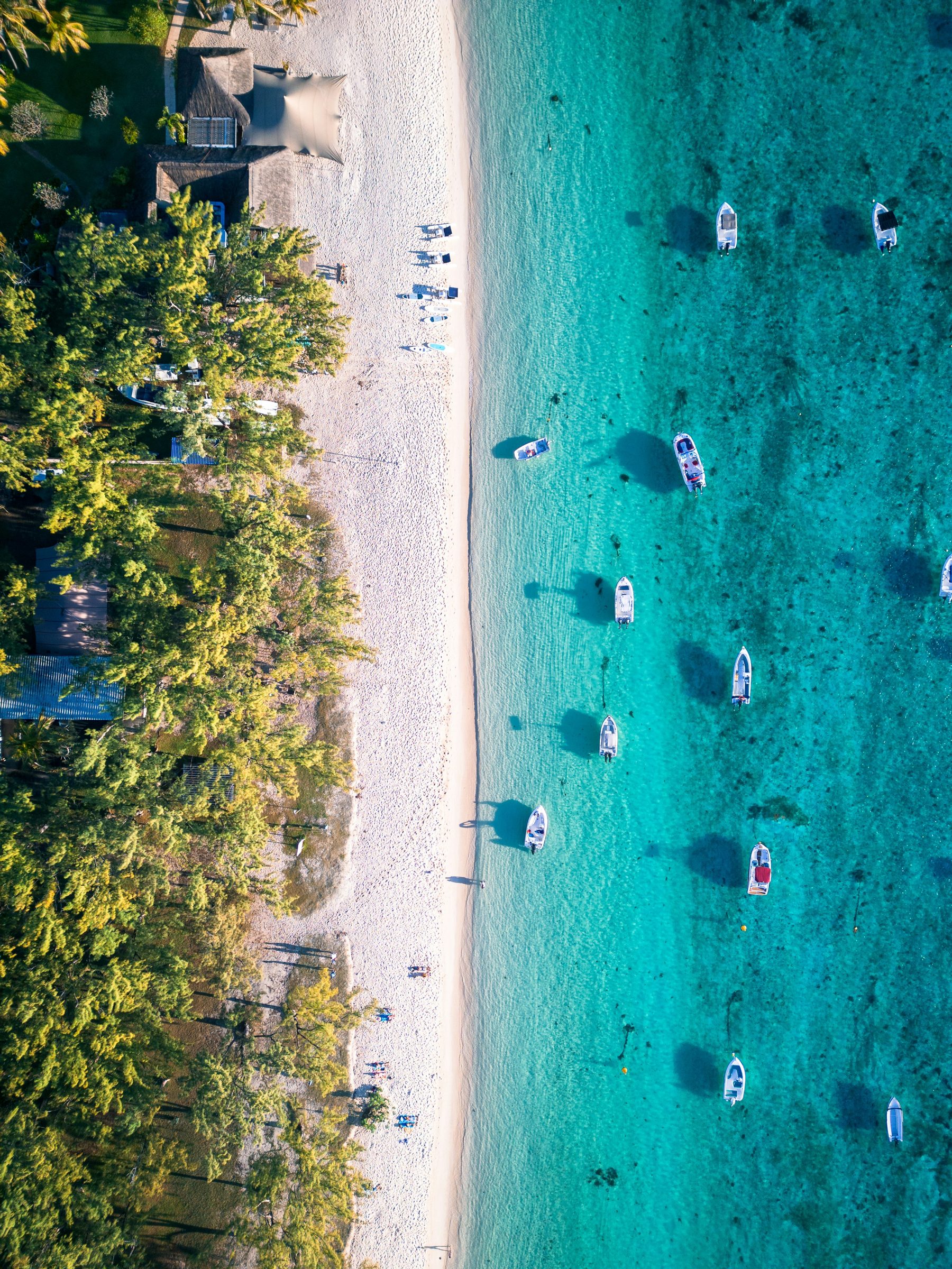 Boats moored in a shallow turquoise lagoon, the east coast, Mauritius