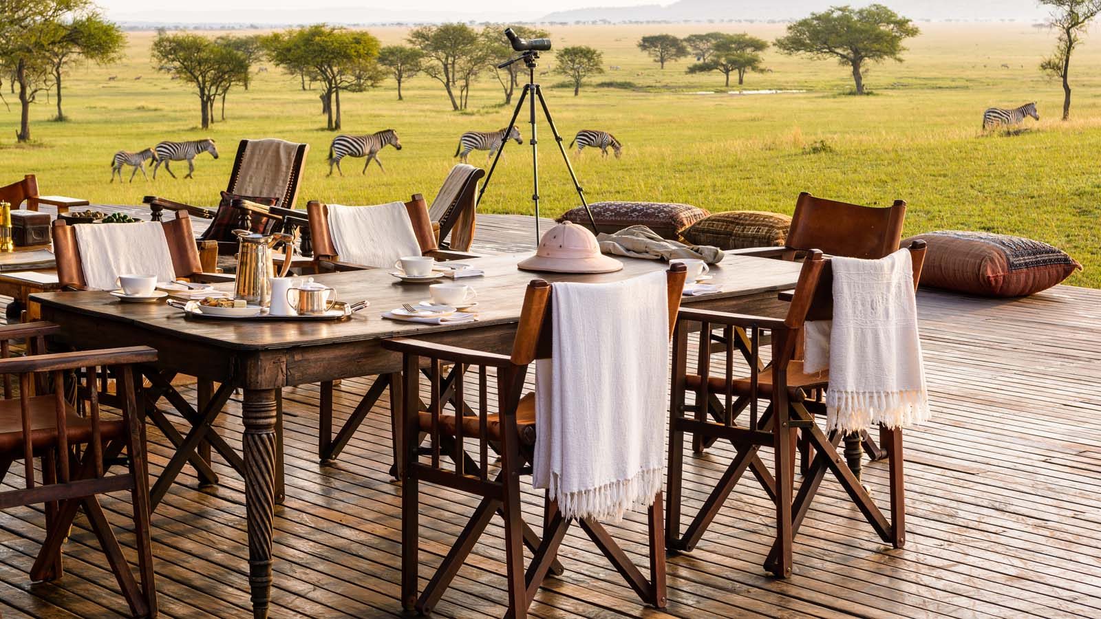Singita Sabora luxury safari lodge in Tanzania, breakfast on the deck as zebra graze the Serengeti plains